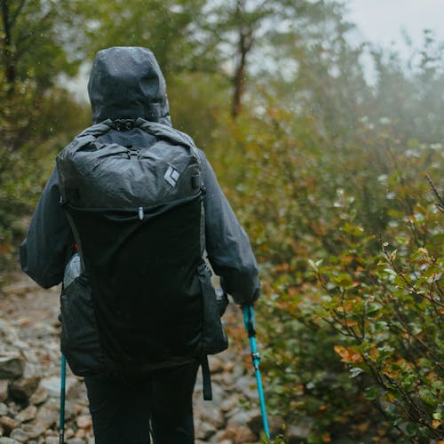A hiker pushes on through a rain storm with the waterproof Beta Light Series Backpack.